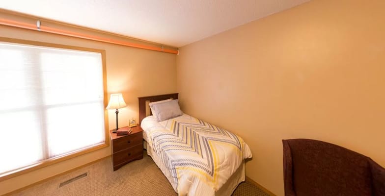 Cozy private room with a bed and lamp