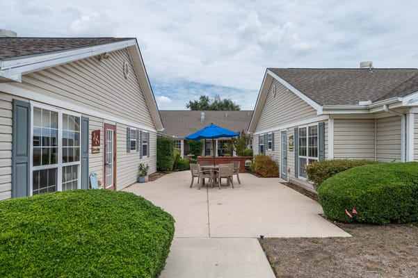 Outdoor seating area with blue umbrella and landscaping
