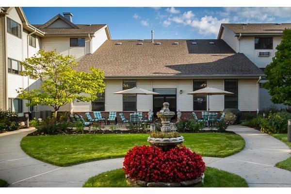 A scenic view of the outdoor patio with a fountain and seating at Richmont Senior Living.