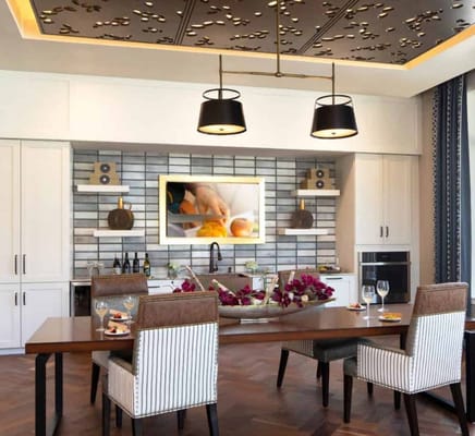 Modern dining area with a wooden table, stylish chairs, and decorative ceiling