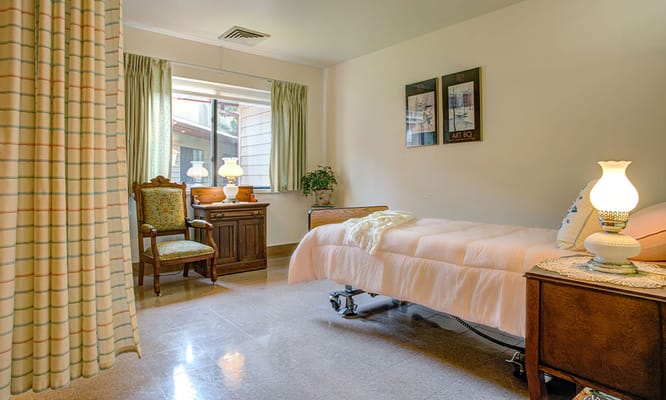 Cozy resident room with bed and armchair