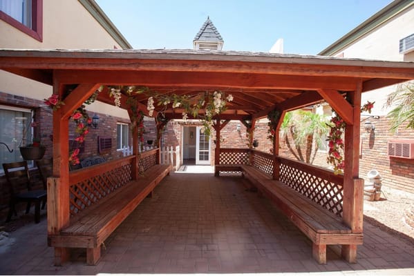 Covered patio area with benches and floral decorations