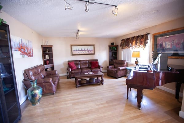 Spacious living room with leather sofas and a piano