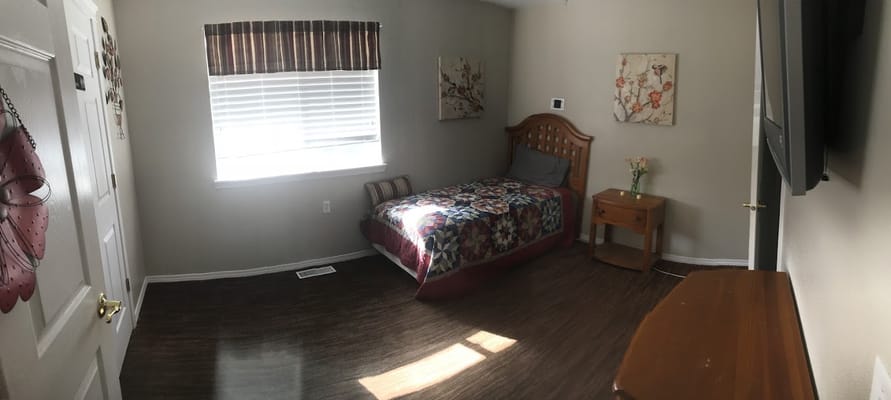 A neatly arranged bedroom with a bed, side table, and window.