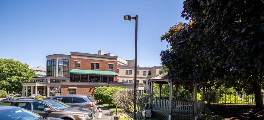 Exterior view of Steere House with gazebo and parked cars