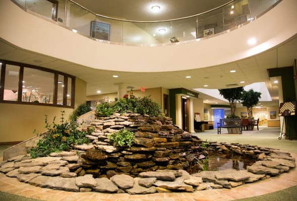 Indoor waterfall with rocks and plants in the lobby