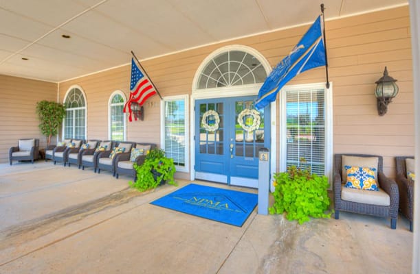Front entrance of Silver Elm Estates with seating and flags
