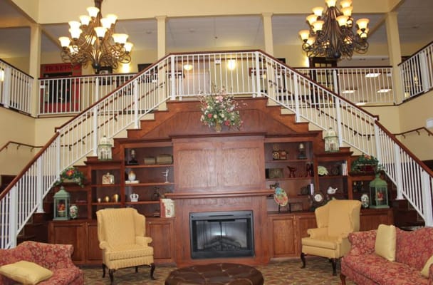 Spacious lobby featuring a staircase, chandelier, and comfortable seating