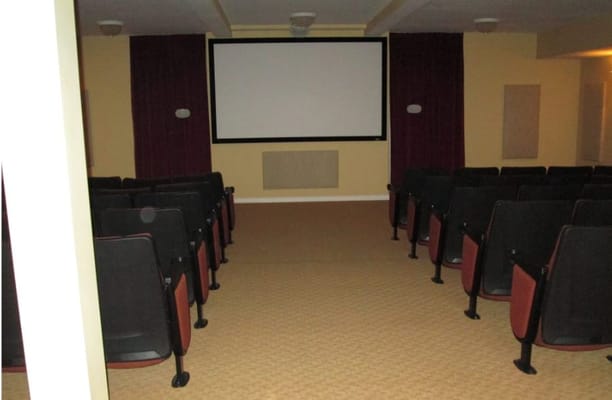 Interior view of the theater room with seating and a large screen