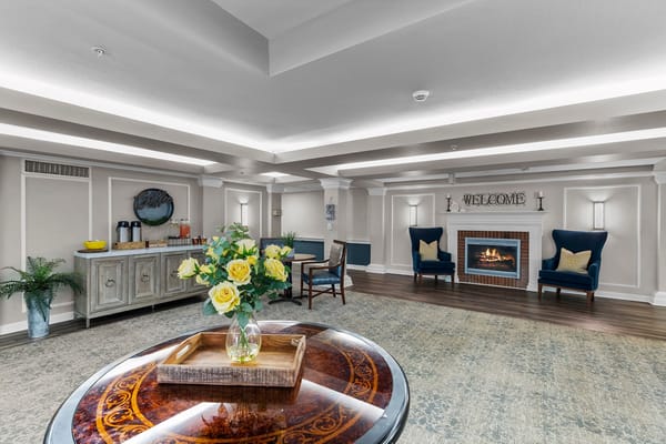Lobby area with a cozy atmosphere, featuring chairs, a decorative table, and a fireplace.