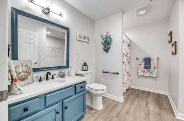 Bright bathroom featuring a blue vanity and floral shower curtain
