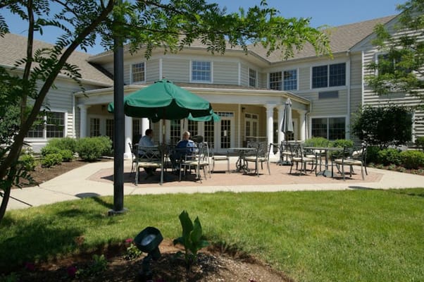 Residents enjoying the outdoor patio area with seating and umbrellas.