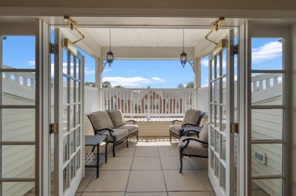 View of a balcony with seating area and open doors at Spring Hills Mount Vernon.