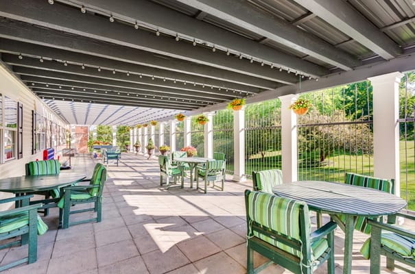 Bright outdoor patio with green striped furniture and hanging plants