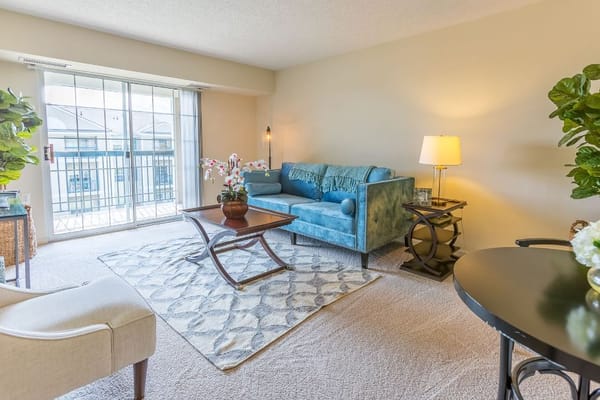 Cozy living room with a blue couch, coffee table, and natural light