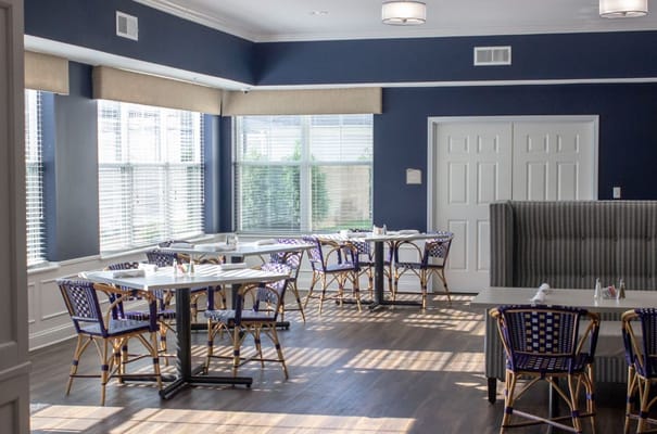 Bright dining area with tables and chairs at StoryPoint Portage.