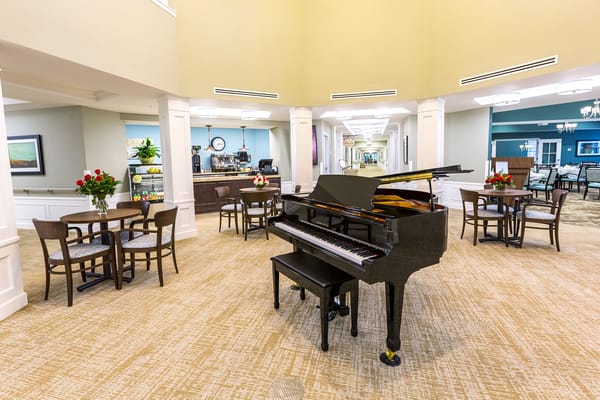 Grand piano in the lobby area with seating and floral arrangements