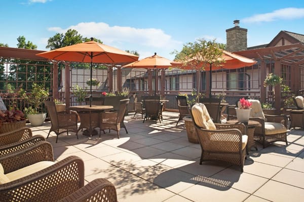 Cozy outdoor patio with wicker furniture and orange umbrellas