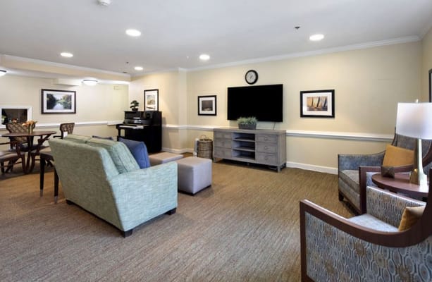 Common room with seating, TV, and piano.
