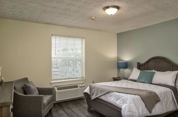 Bright, inviting resident room with a bed and seating area