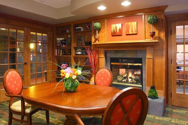 Cozy dining table with flowers and a fireplace in a common area