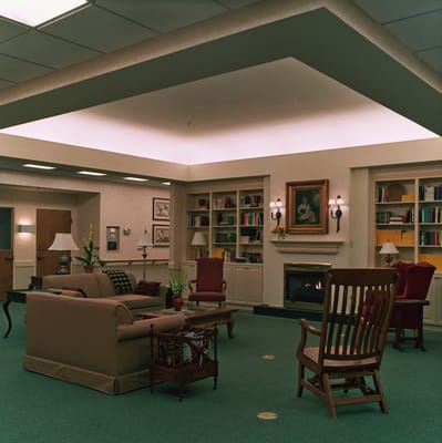A cozy living room with seating, shelves, and a fireplace in The Breckinridge.