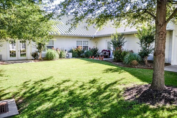 Courtyard with green grass and bushes outside resident rooms