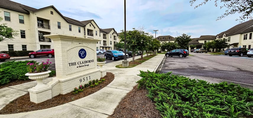 View of the front entrance sign and parking lot at The Claiborne at Baton Rouge