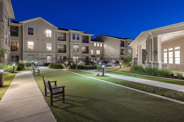 Outdoor space with benches and pathway at night.