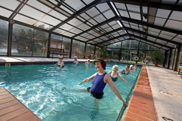 Seniors enjoying a water exercise class in the indoor pool.