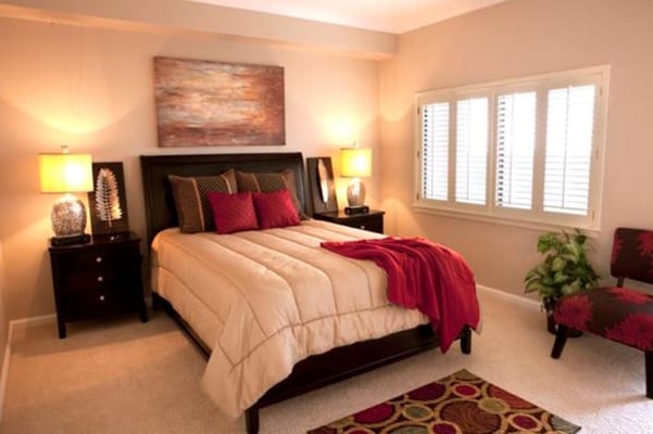 Well-decorated bedroom with a bed, lamps, and seating area