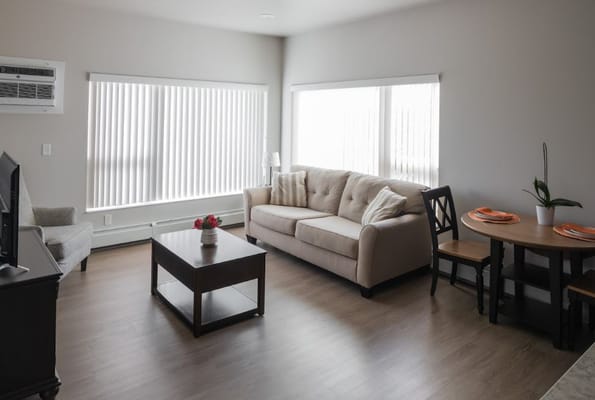 Cozy living room with couch, coffee table, and dining area