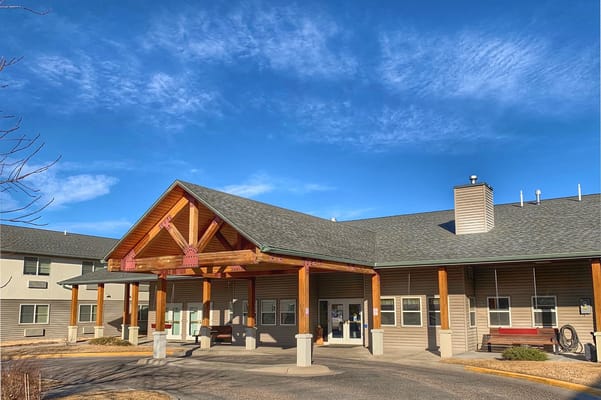 Main entrance of The Lodge Senior Living with a wooden canopy