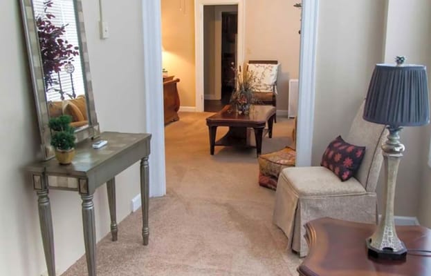 Entrance to a cozy living room with a small table and lamp
