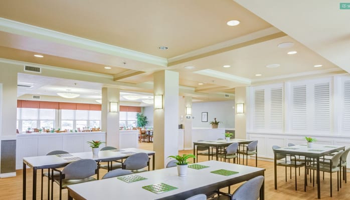 Brightly lit dining room with tables and greenery at The Plaza at Mililani