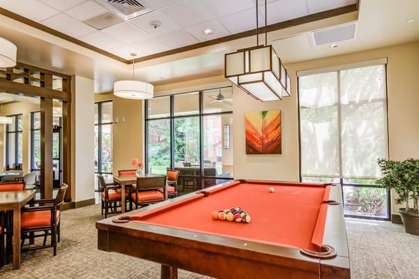 A billiards table with colorful balls in a well-lit recreation room.
