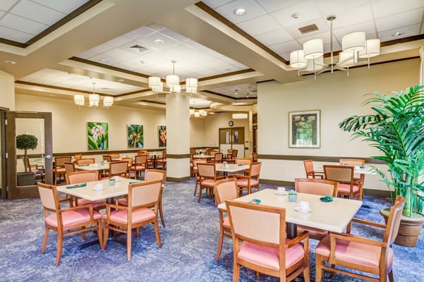 Brightly lit dining room with tables and chairs