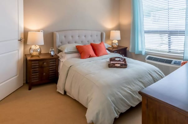 A cozy bedroom featuring a bed with decorative pillows and bedside tables