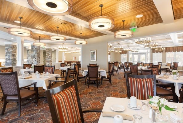 Bright dining area with tables set for residents