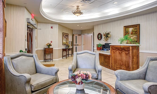 Cozy lobby area with two armchairs and a reception desk.