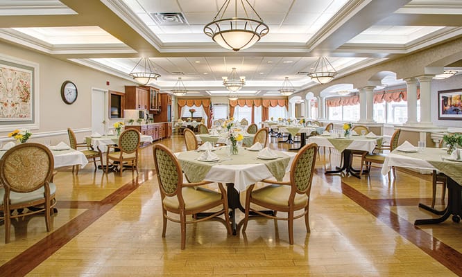 Brightly lit dining room with tables set for dining.