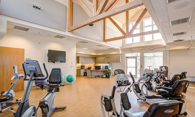 Bright and spacious gym with exercise equipment at The Village Health & Rehabilitation