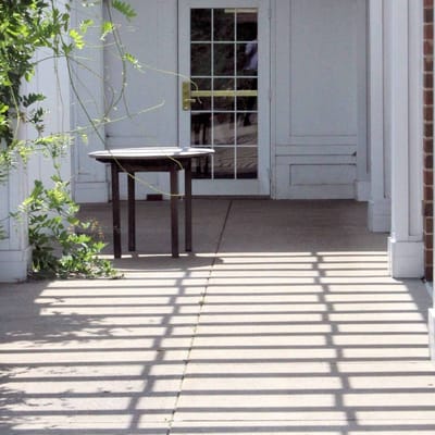 Table near entrance with shadows on the ground.