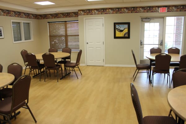Interior of a common room with tables and chairs.