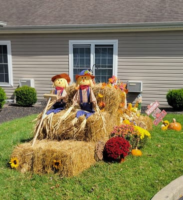 Outdoor fall decorations with scarecrows and pumpkins