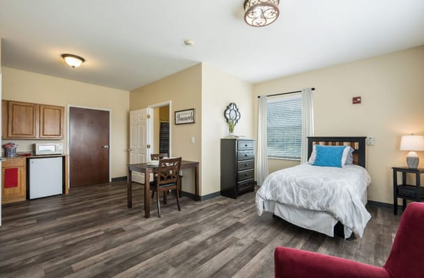 Interior of a spacious resident room with kitchenette and furnishings