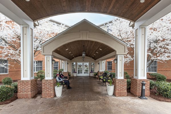 Residents relaxing in a covered outdoor area with flowers
