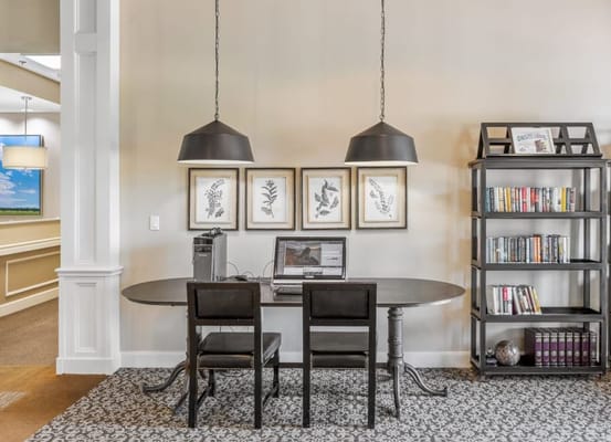 Cozy community office featuring a desk, chairs, and bookshelves