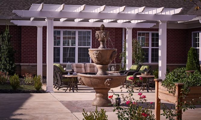 Outdoor seating area with a fountain and flowerbeds