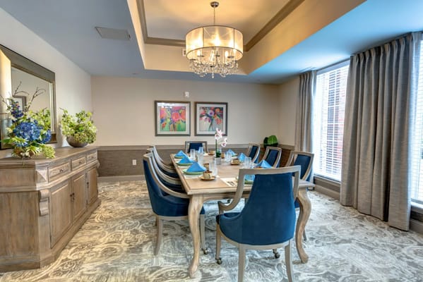 Elegant dining room setup with blue chairs and floral decor